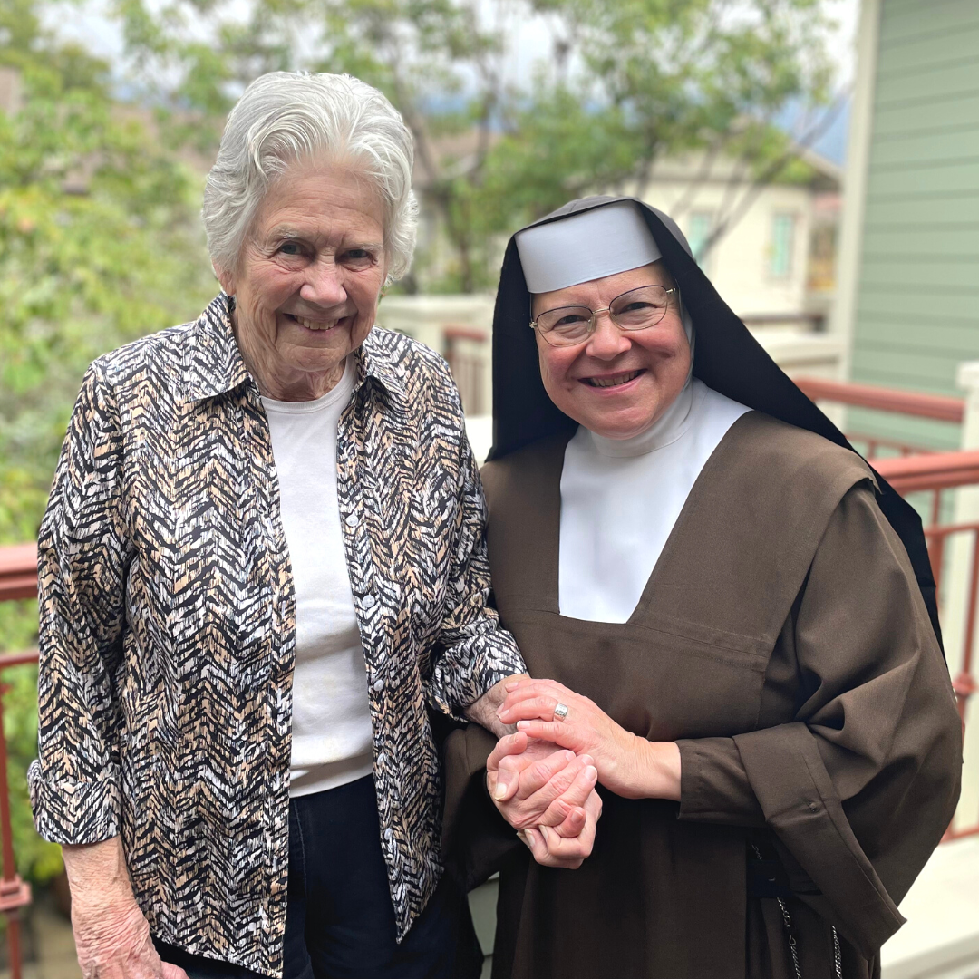 Sister and resident standing together and smiling.