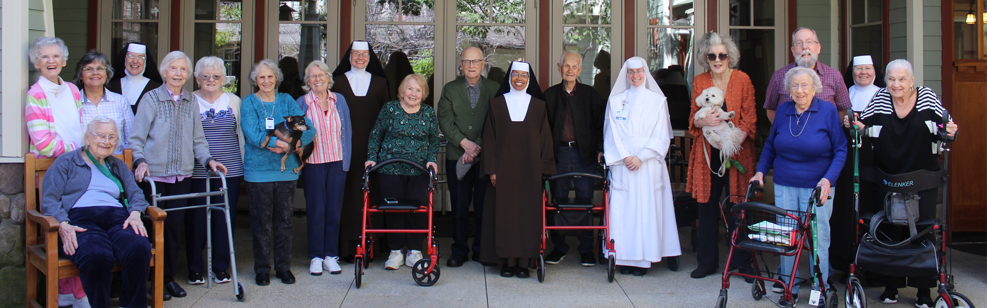 Sisters standing with smiling residents outside Good Shepherd Cottage.