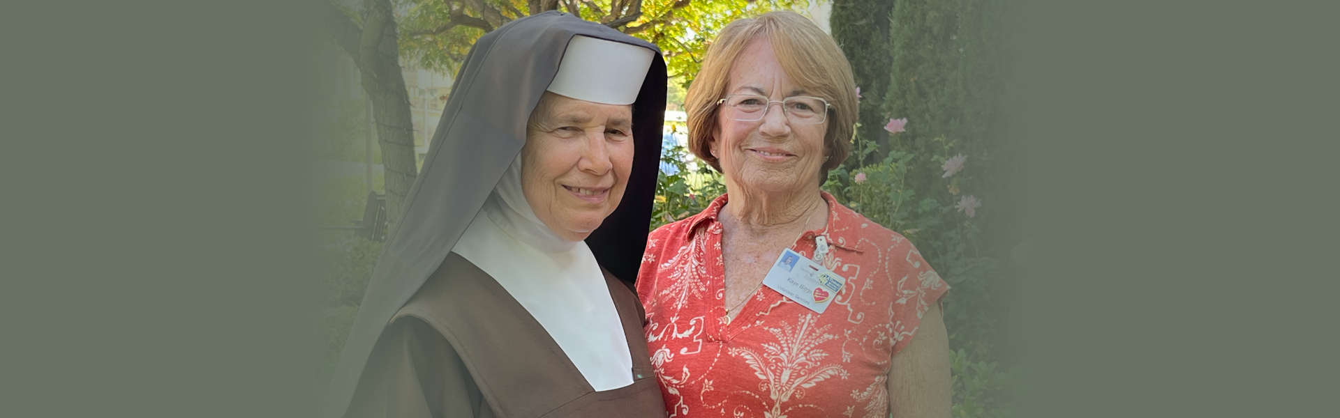 A sister and a volunteer smile at the camera.