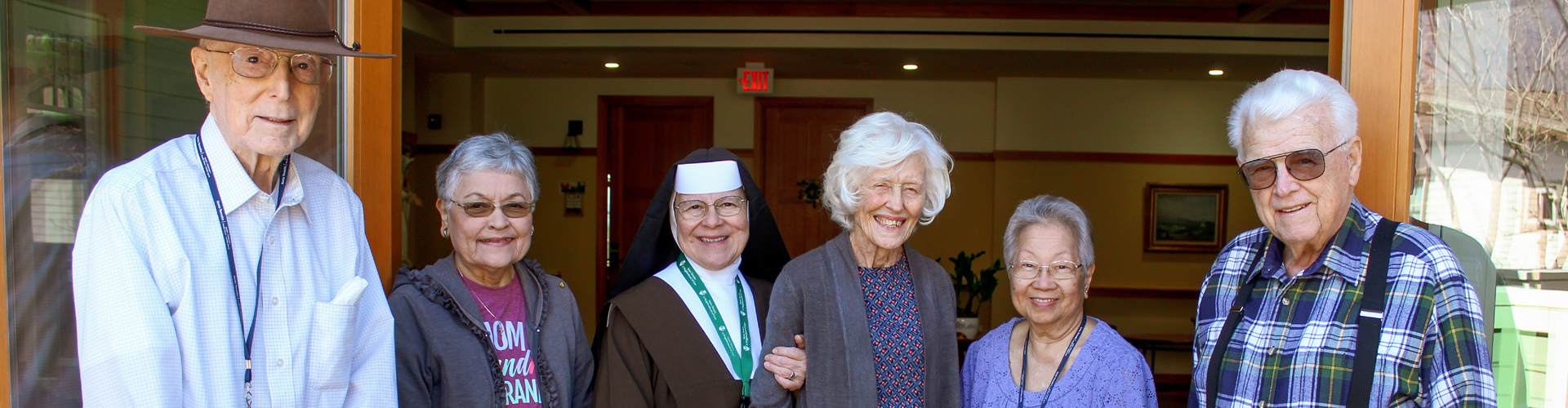 Sister standing with other residents, smiling at the camera